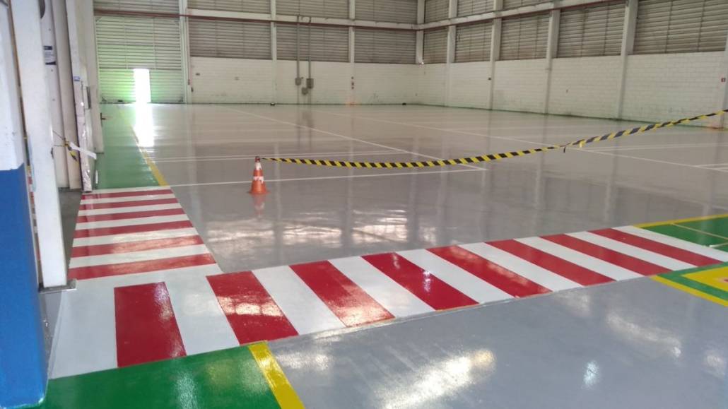Galpão industrial com piso em epóxi e demarcação de faixas de segurança